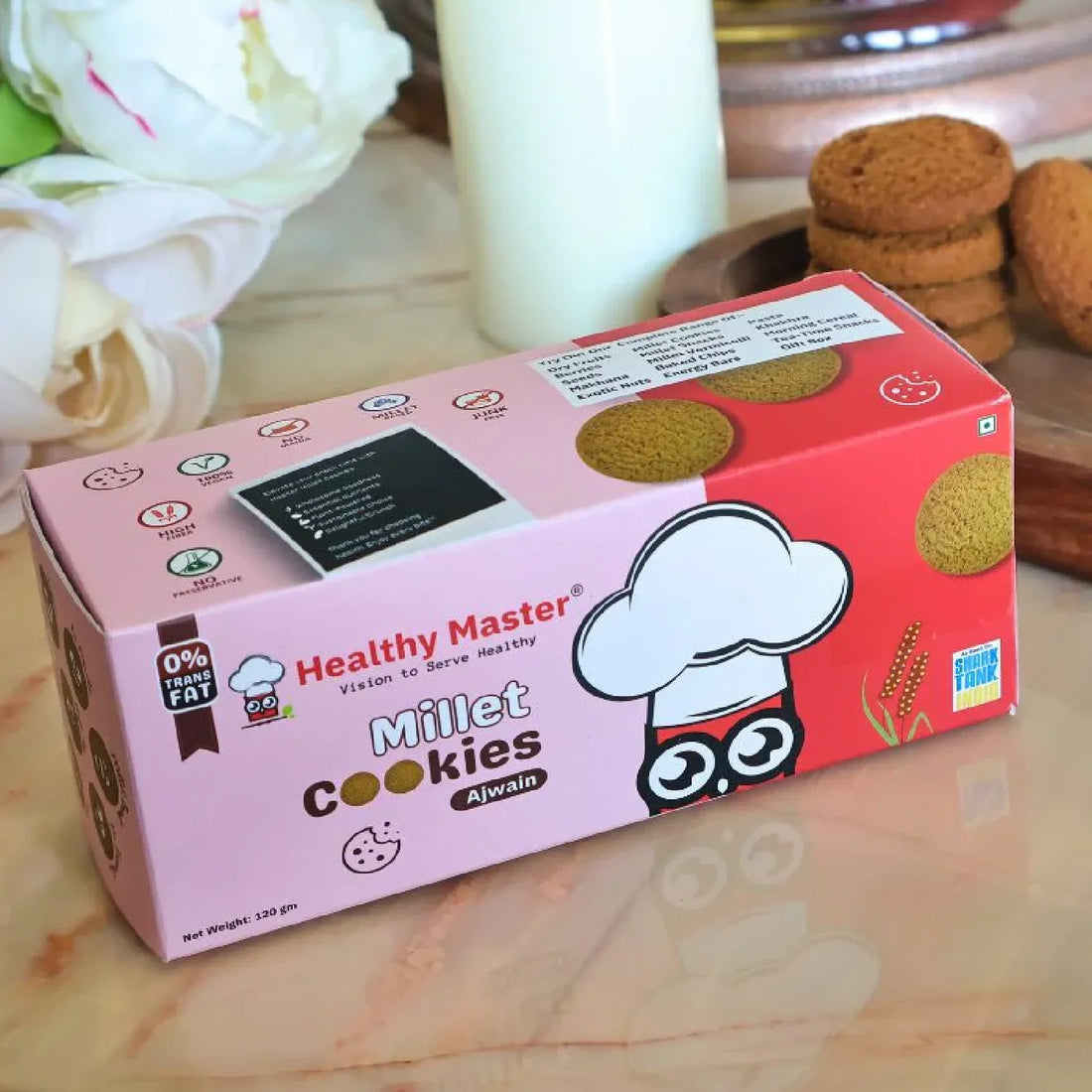 Healthy Master Millet Cookies with Ajwain, 0% trans fat, stacked on marble with golden decor and fresh cookies nearby