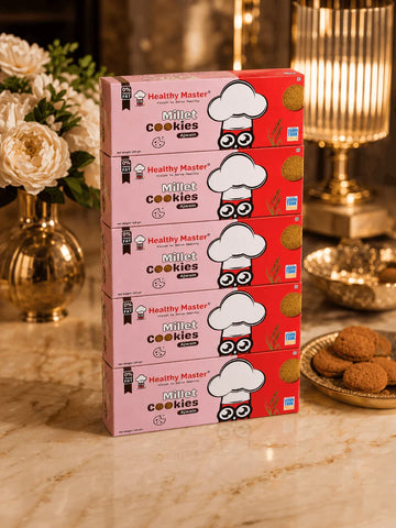 Healthy Master Millet Cookies with Ajwain, 0% trans fat, stacked on marble with golden decor and fresh cookies nearby