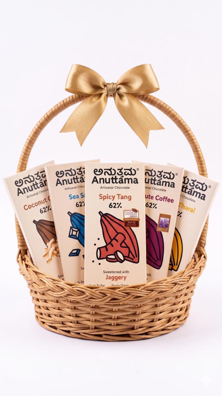Artisanal jaggery-sweetened chocolate bars in a wicker gift basket with gold bow, featuring Spicy Tang, Coconut, and more flavors.